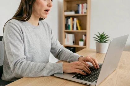 Femme utilisant des raccourcis clavier sur un ordinateur portable dans un bureau à domicile moderne